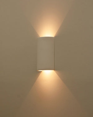 Cylindrical wall light on a beige wall