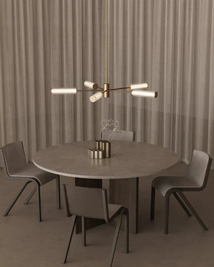 Dining area with luxury designer modern chandelier against a neutral curtain background.