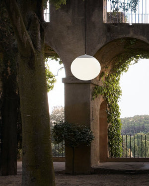 Light fixture hanging from an archway with a scenic view in the background