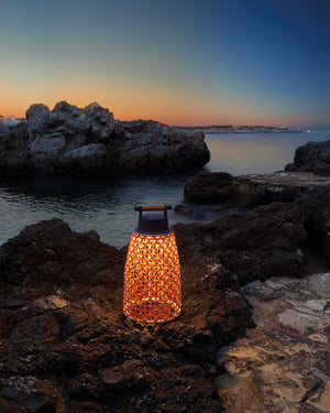 Lantern on a rocky beach at sunset