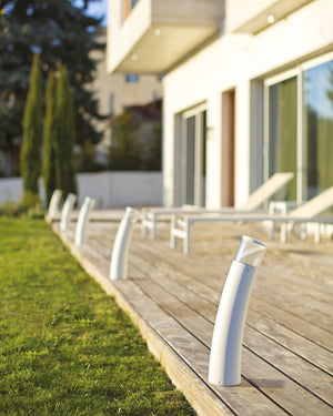 White outdoor lamp posts on a wooden deck with a house in the background