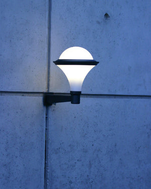 Wall-mounted outdoor light fixture on a concrete wall