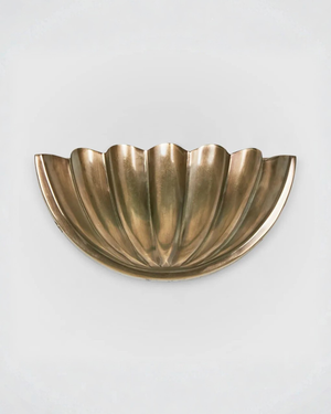 Brass shell-shaped wall sconce light gray background