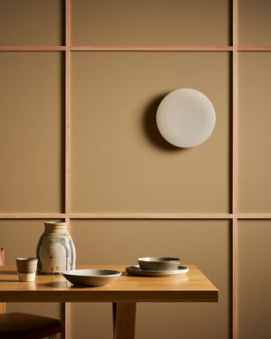 Ceramic wall light fitting above dining room table