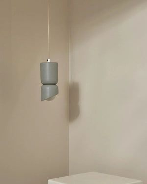 Gray pendant light hanging against a beige wall