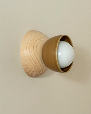 Wooden wall light fixture with a white bulb on a beige background