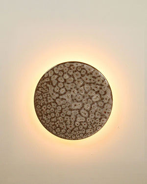 Illuminated small ceramic disc wall light in white ochre finish
