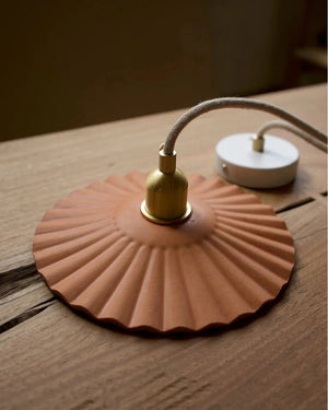 handmade leather pendant sitting on a table with a withe ceiling plate