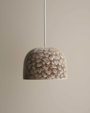 Textured pendant light fixture on a neutral background