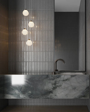 A cluster of handmade sora frosted glass pendant lighting hanging above a modern style bathroom sink