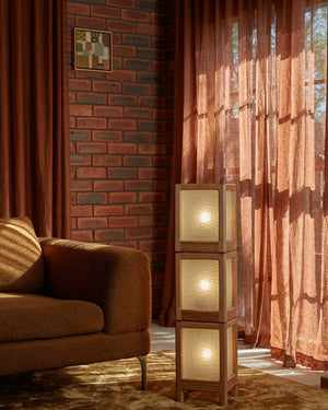 Handmade timber floor lamp with warm light on in an Australian warm organic interior living room