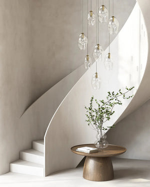Modern interior with a wooden table, vase with greenery, and glass pendant lights.