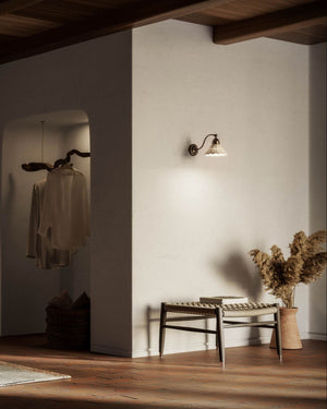 Italian Embroidery Ceramic Wall Light mounted on white wall above a woven bench in warm Mediterranean interior