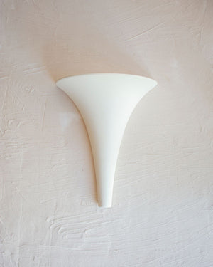 White wall sconce on a textured white wall