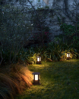 Three bollard lights with Corten finish in a garden
