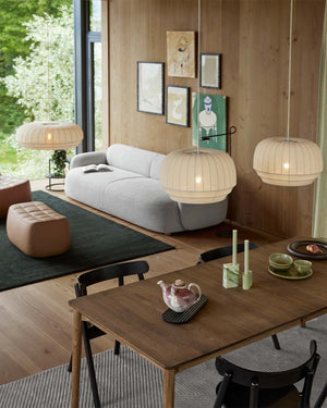 Modern living room with a wooden table, white sofa, and pendant lights.