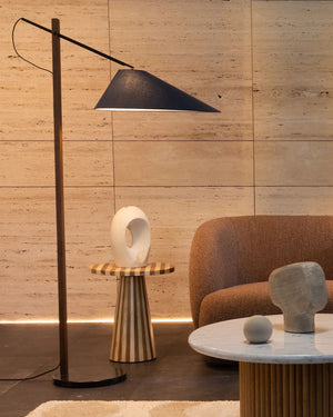 Modern interior with a floor lamp, side table, and armchair against a wooden wall.