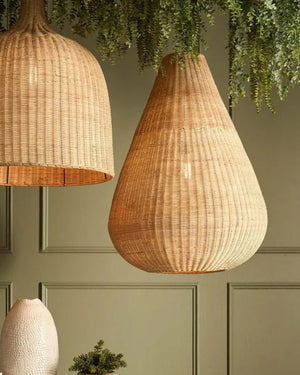 Woven pendant lights hanging against a green paneled wall.
