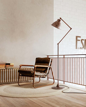 Pre aged industrial adjustable floor lamp in a minimalist reading nook