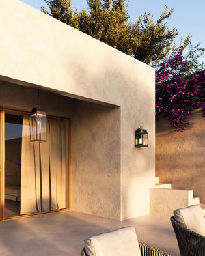 Italian Faux Candle Exterior Wall Lantern Placed on a textured beige wall of a modern Mediterranean house near a terrace