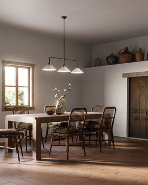 Traditional three light pendant hanging over a dining table in a rustic interior