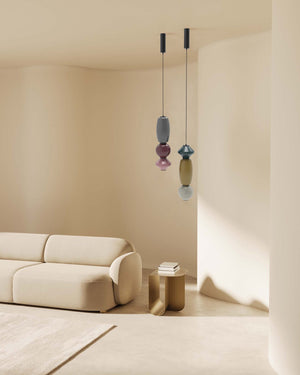 Modern living room with a beige sofa and colorful pendant lights.