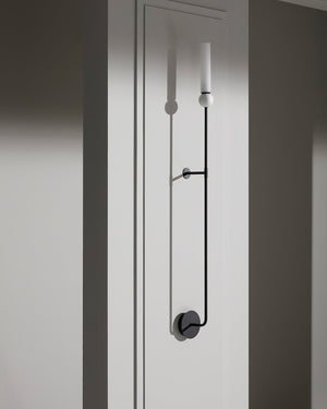 Modern door handle on a white door with a black pull rod.