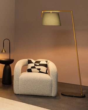 Modern large floor lamp in a living room with an arm chair, art on the wall and small table lamp