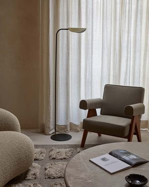 Modern living room with a gray armchair, Minimalist Folded Shade Floor Lamp, and round coffee table.