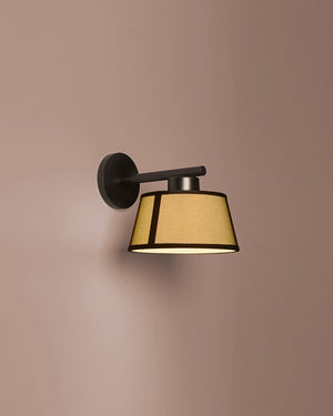 Wall-mounted light fixture with a beige shade on a brown background