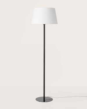 Floor lamp with a white shade and black base on a light gray background