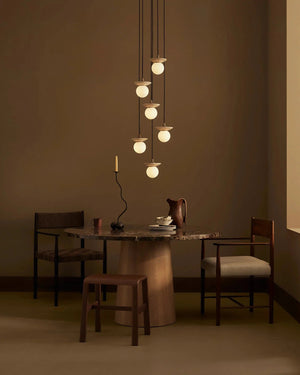 Dining area with a round table, chairs, and a Natural Stone Orb 6 Light Chandelier 