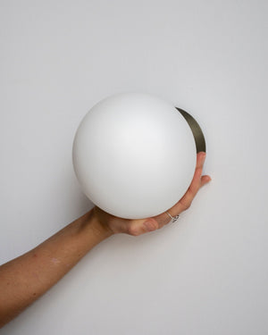 Hand holding a Opal Glass Indoor & Outdoor Wall Light by Lighting Collective