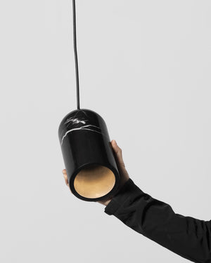 Person holding a black pendant light with marble pattern