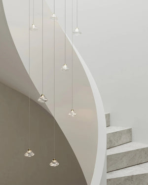 Organic glass round flo pendants suspended next to a white spiral staircase