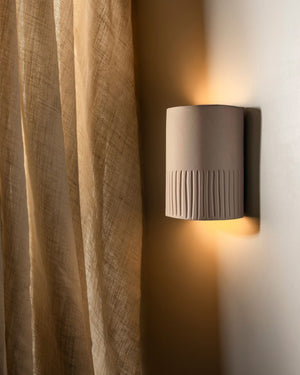 Wall light with stone finish and indents on bottom