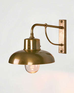 Outdoor Farmhouse Brass Wall Light in antique brass with dome shade and curved gooseneck arm on white background