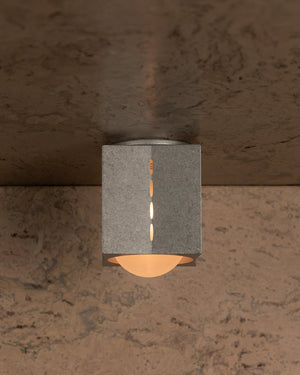 Square wall-mounted light fixture on a textured wall