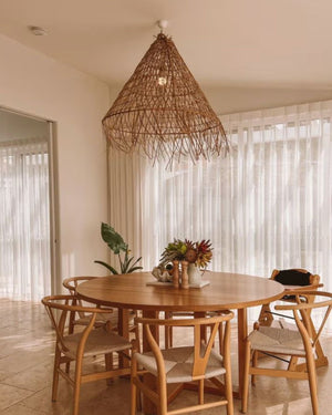 Frayed rattan pendant styled above a dining table