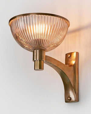 Ribbed glass and metal wall light in dark brass finish with textured glass shade