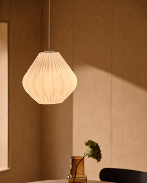 Pleated glass pendant light installed above dining table