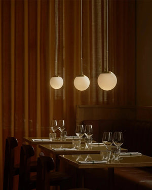 Simplistic Opal Sphere Pendant in a row of three in a luxurious restaurant - Lighting Collective 