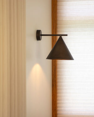 Straight Arm Iron Cone Wall Light with Morocco finish near a window
