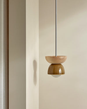 Wooden and ceramic pendant light fixture on a neutral background