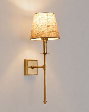 Tapered shade brass stem wall light in brass and copper finish with warm light on