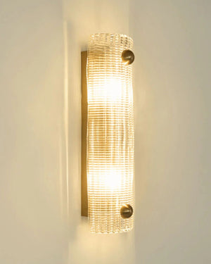Textured Glass Wall Light in brass mounted on wall casting warm scattered light through crosshatch glass panel