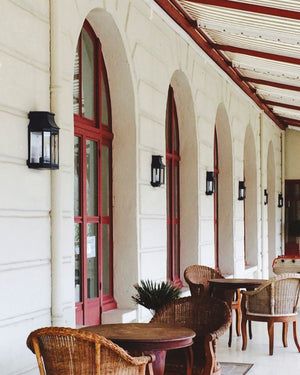 An outdoor patio with traditional french-style lanterns on the facade